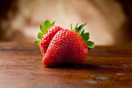 木制桌上的草莓水果树叶甜点浆果桌子红色背景图片