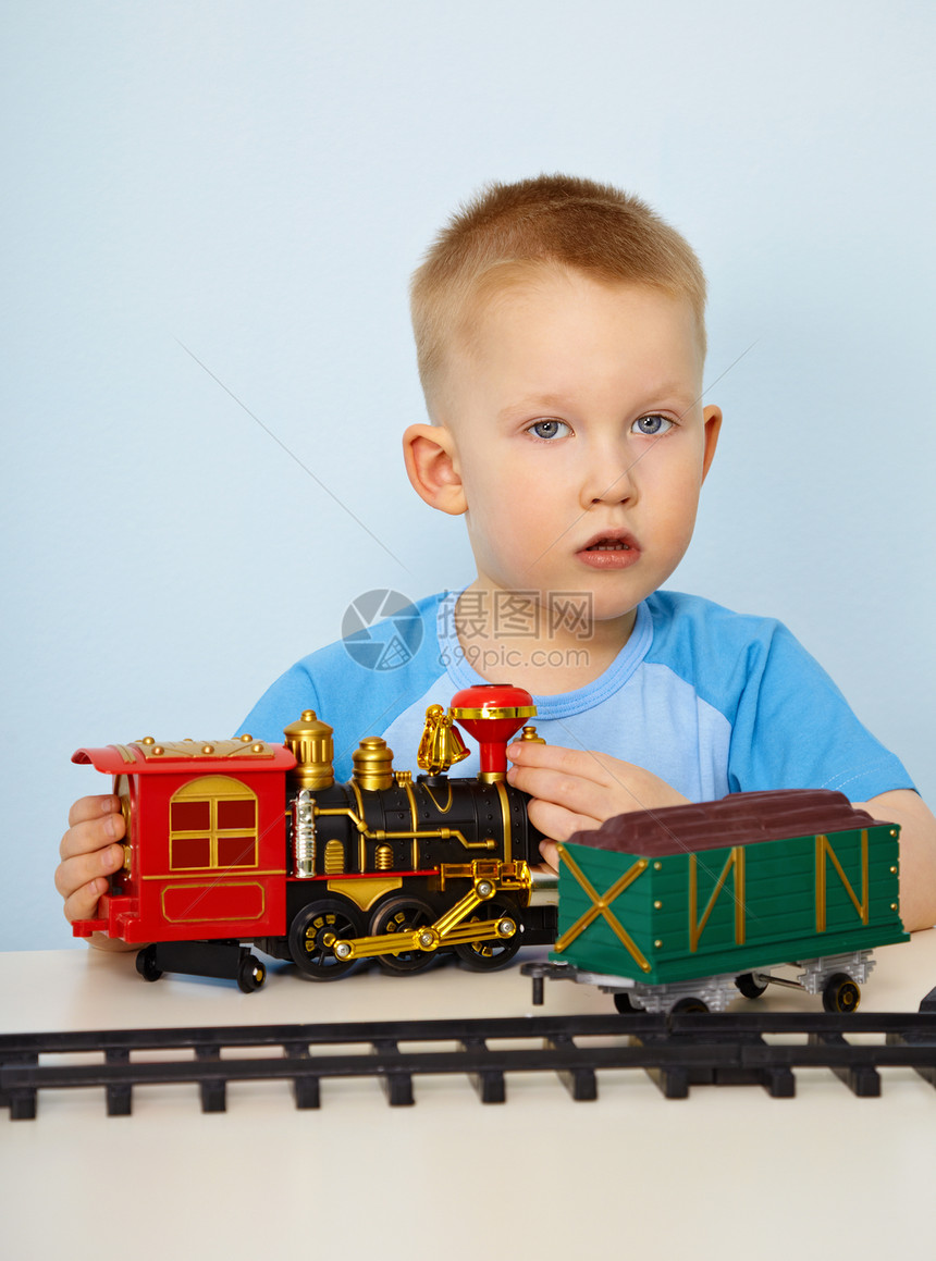 小男孩玩玩具机车小男孩持有桌子铁路白色男生运输照片塑料教练戏剧图片