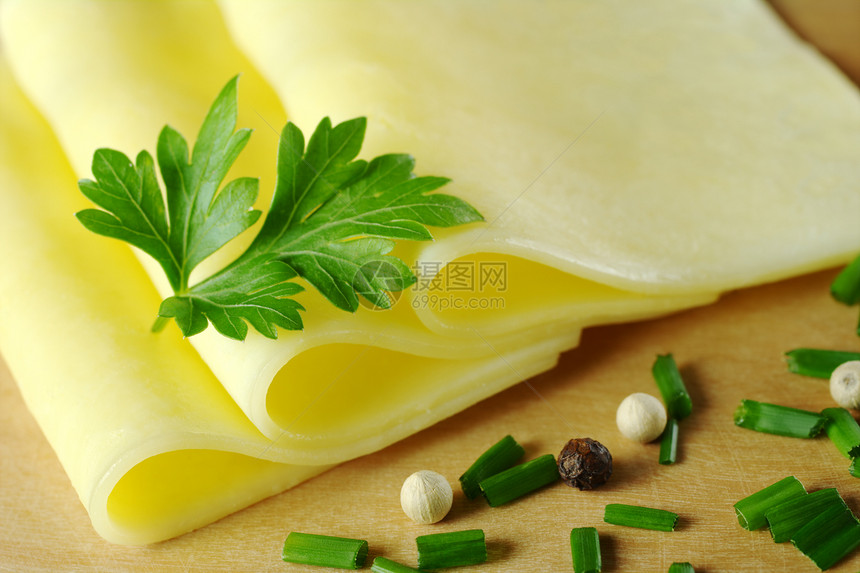 奶酪切片棕色玉米木头水平宏观黄色奶制品杂货绿色叶子图片