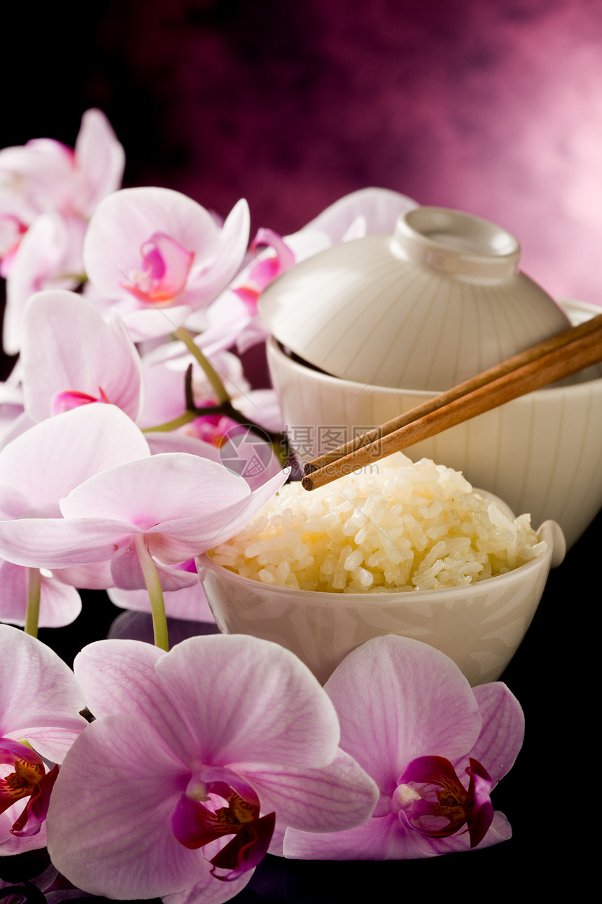配有兰花花的亚洲大米饭筷子陶器花朵聚光灯粮食树叶小菜反射美食桌子图片