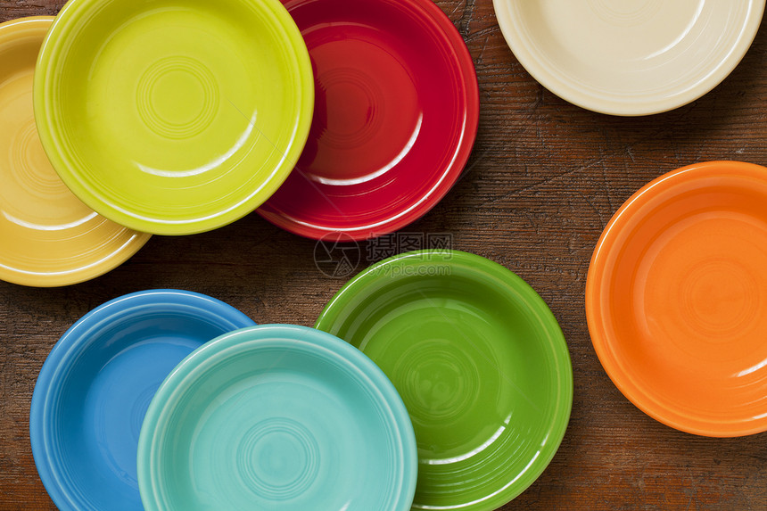 抽象的彩色陶瓷碗绿色黄色制品橙子红色圆形盘子木头风化图片