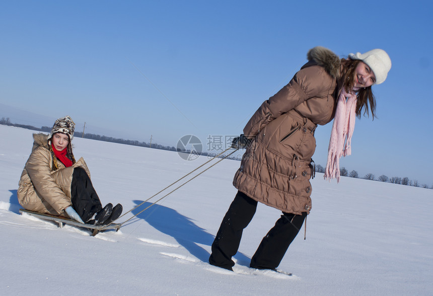 两个快乐的姐妹在冬天滑雪天气游戏友谊平底下雪乐趣速度享受童年帽子图片