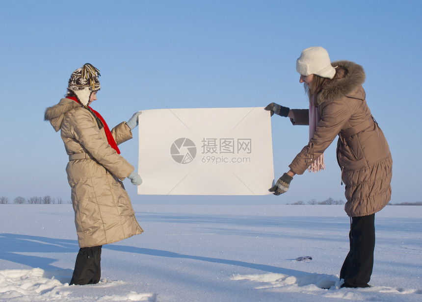 女孩在冬季雪田时张贴白海报标语蓝色纸板女孩们公告女性童年商业广告快乐图片