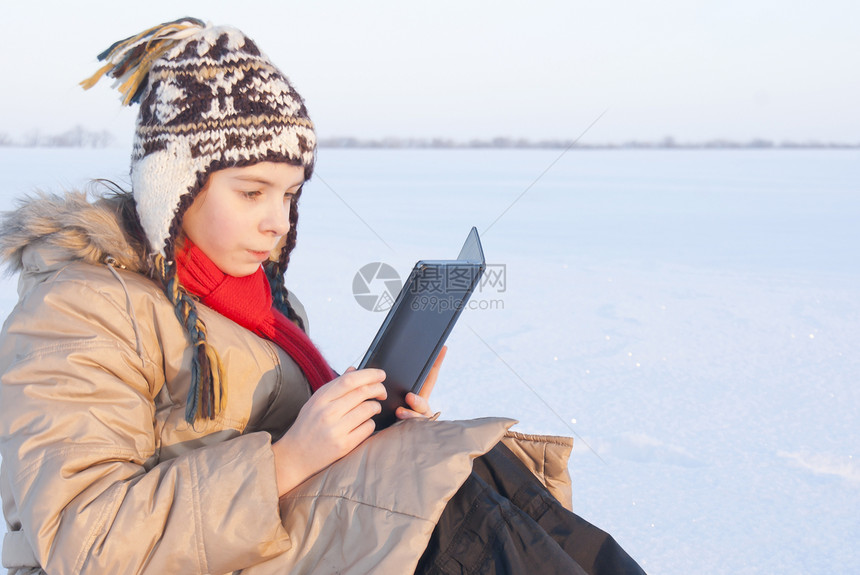 冬季在户外阅读电子书的少女文学成人快乐活动闲暇水平女士白色图片