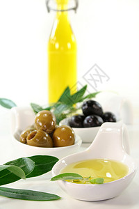 橄榄油美食家橄榄枝生物黑色产物绿色金黄色食物瓷碗冷压背景图片