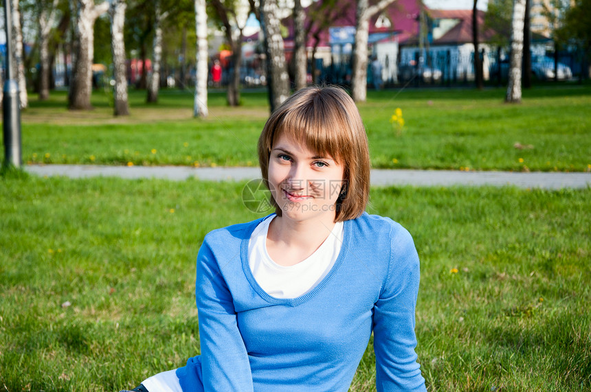 坐在公园里笑着的女孩乐趣享受闲暇绿色头发快乐女性图片