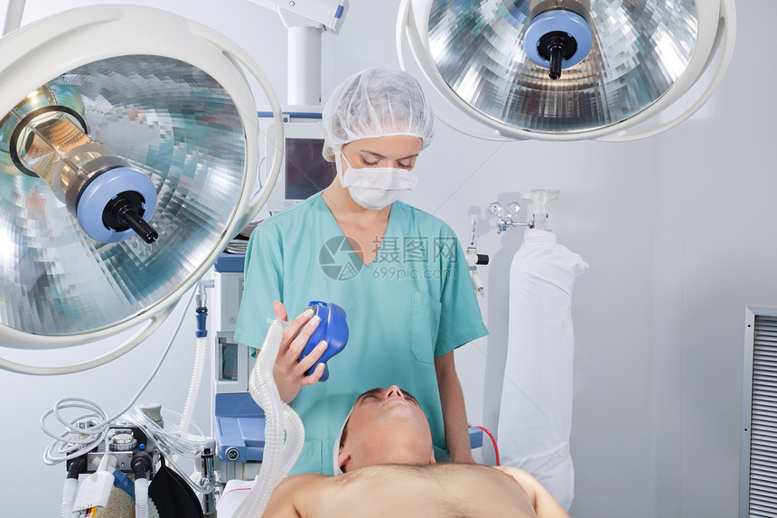 医生使用氧气罩女性女士男性治疗病人手术卫生说谎监视成人图片