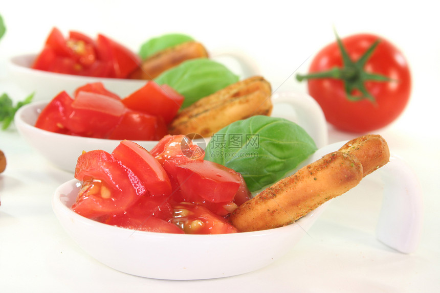格里西尼与番茄和巴西零食瓷碗沙拉菜勺白色勺子小吃面包美食自助餐图片