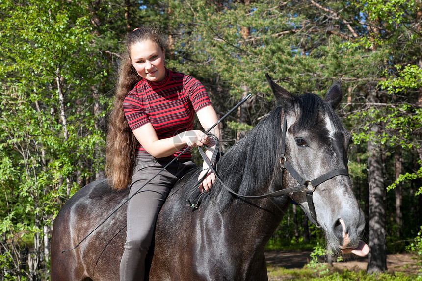穿黑马的漂亮女孩动物天空森林乡村阳光青少年场景训练女性马背图片