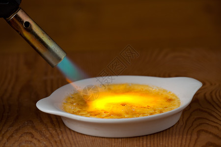 燃烧火焰 熔化一块小黑食物钎焊奶油焦糖焦糖化火炬香草黄色棉花甜点背景图片