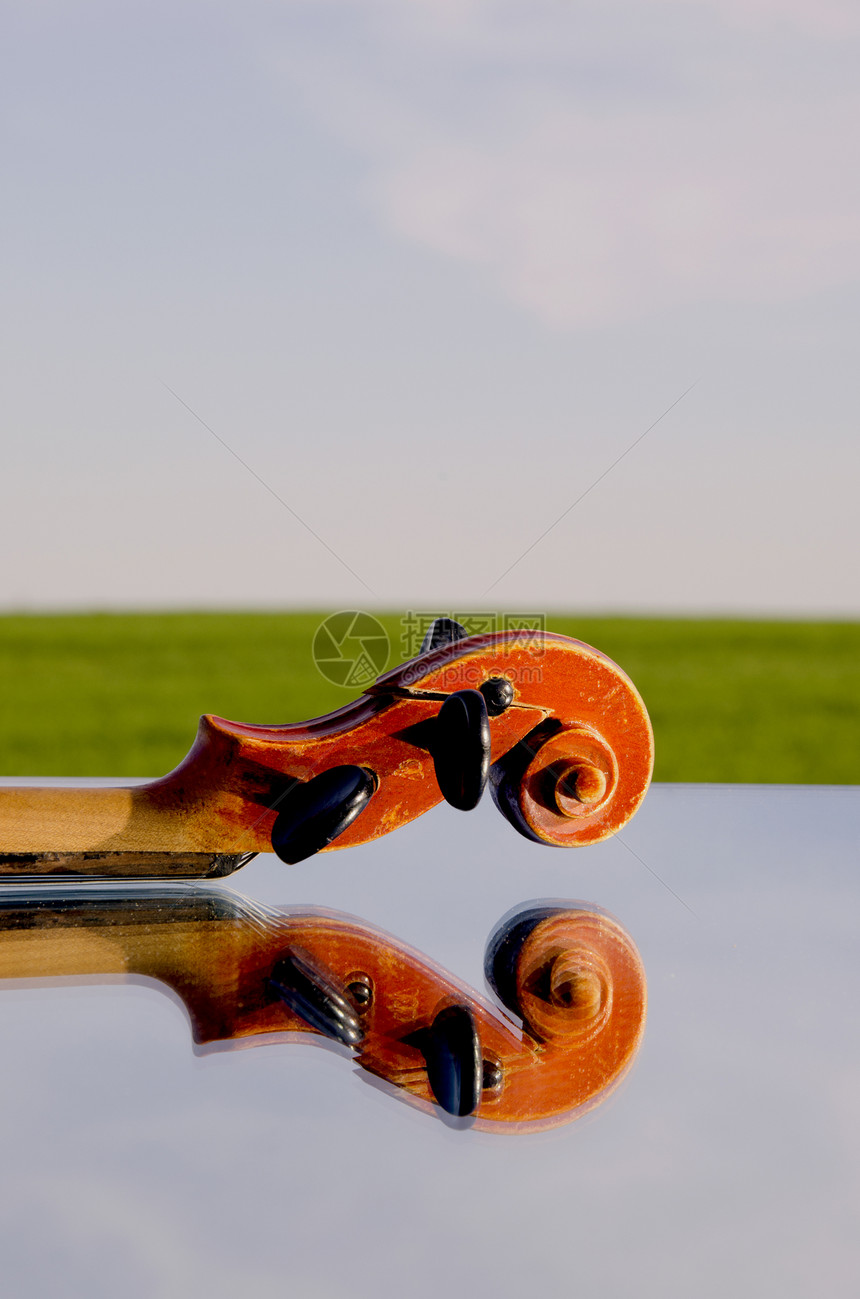 镜子上的老小提琴碎片乐器交响乐木头房子细绳古董音乐会艺术天空反射图片