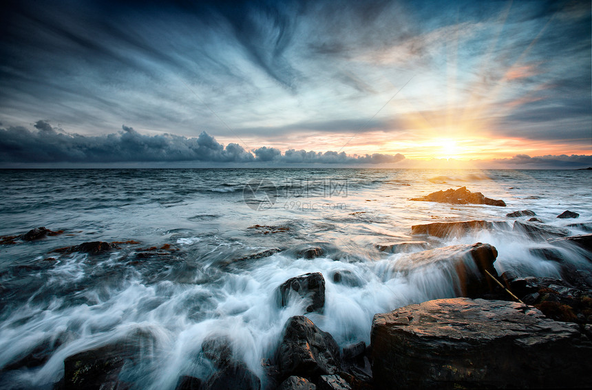 日落在海边石头冲浪风景风暴反射飞溅地平线天空边缘图片