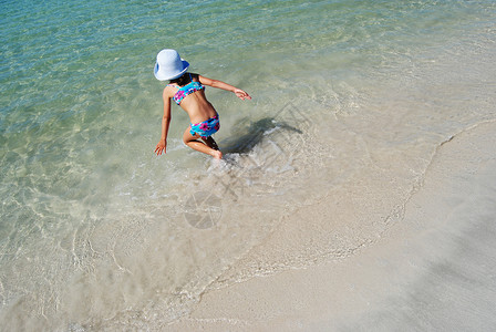 泳装步行在水中游戏海岸游泳孩子女性跑步晴天蓝色假期女孩海岸线背景