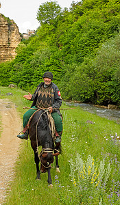 北高加索一个骑马的老山地居民背景