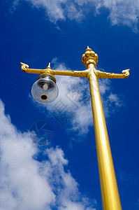 一个金色的灯柱 站在蓝天上背景图片