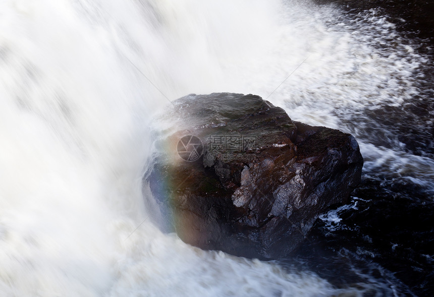 瀑布中的岩上彩虹图片