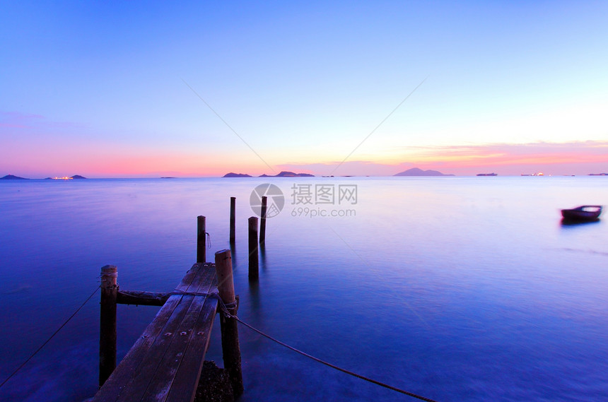 魔力时日落 沿着木甲码头海岸假期旅行墙纸热带金子蓝色天空海洋反射图片