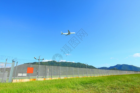 波音公司飞机白天飞越草地上空背景