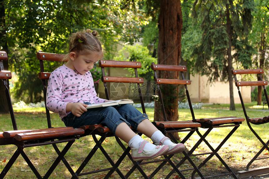 小女孩在读书青年乐趣学习阅读女孩童年公园孩子故事女儿图片