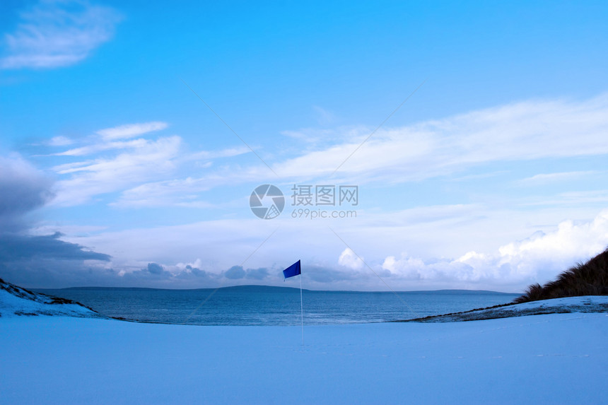 绿色高尔夫 冬季雪和蓝旗图片