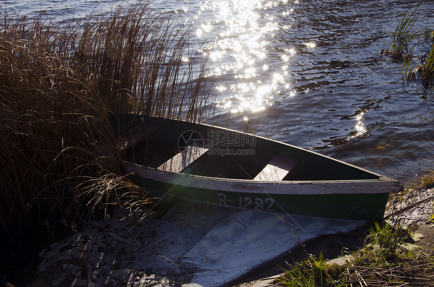 挂号的木制船锁在湖岸图片