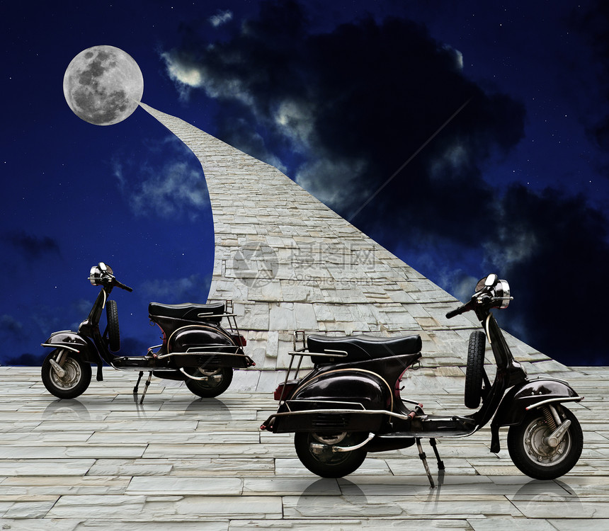 黑色回程小摩托车和通向月球的石路图片