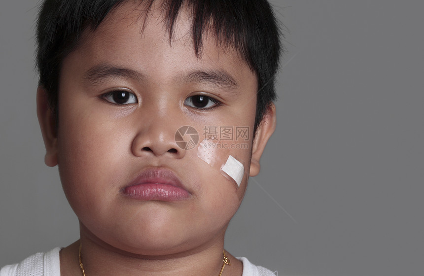 一个年轻男孩的肖像划痕情感急救病人绷带愈合帮助男性创伤皮肤图片