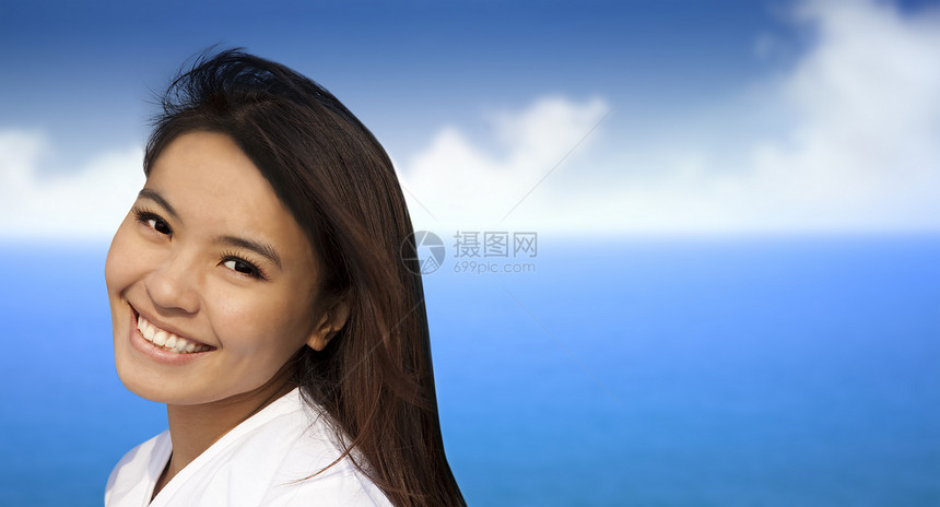 蓝色海洋背景的美丽的亚洲年轻女性青年女子图片