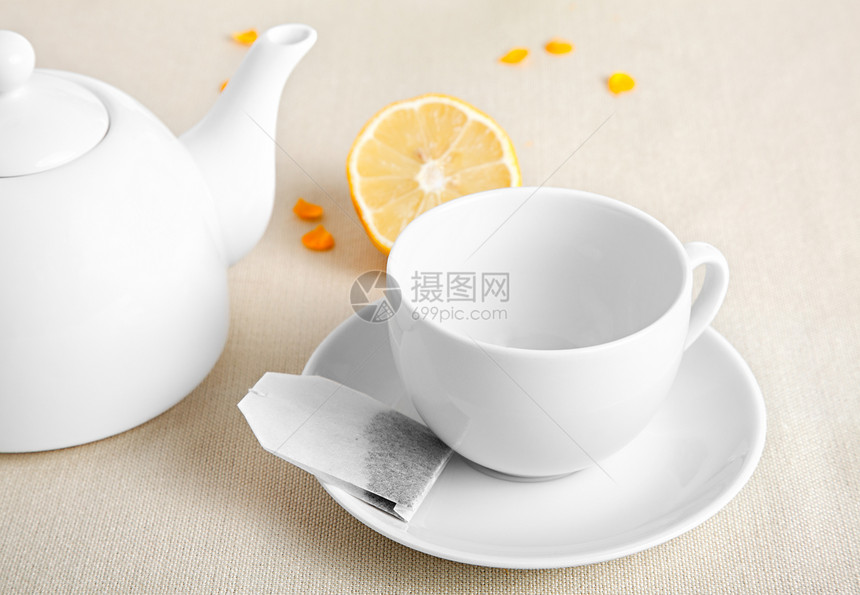 装茶袋的茶杯飞碟草本茶壶陶瓷黄色食物黑色早餐白色饮料图片