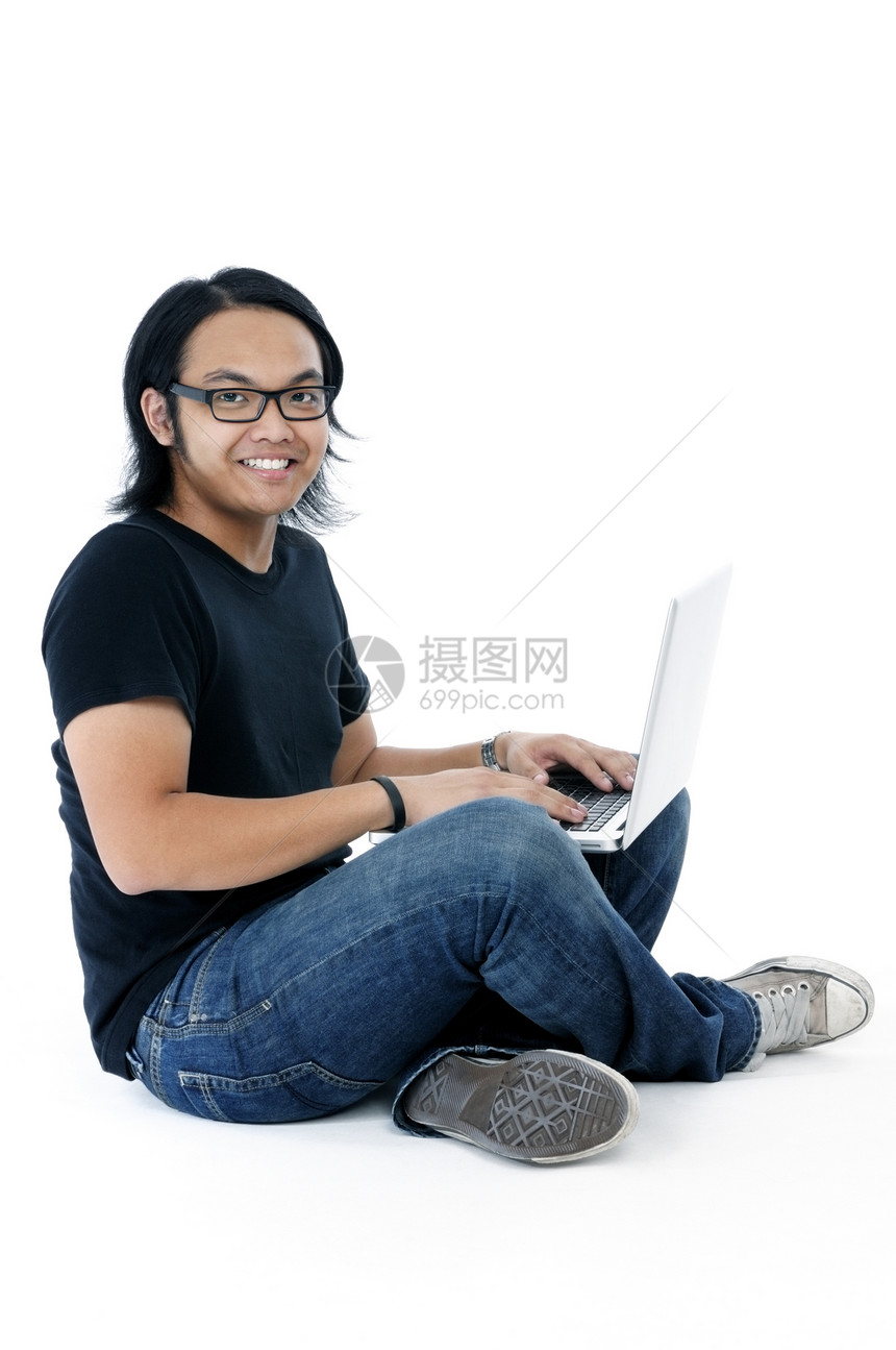 带着笔记本电脑坐在地板上快乐的年轻人图片