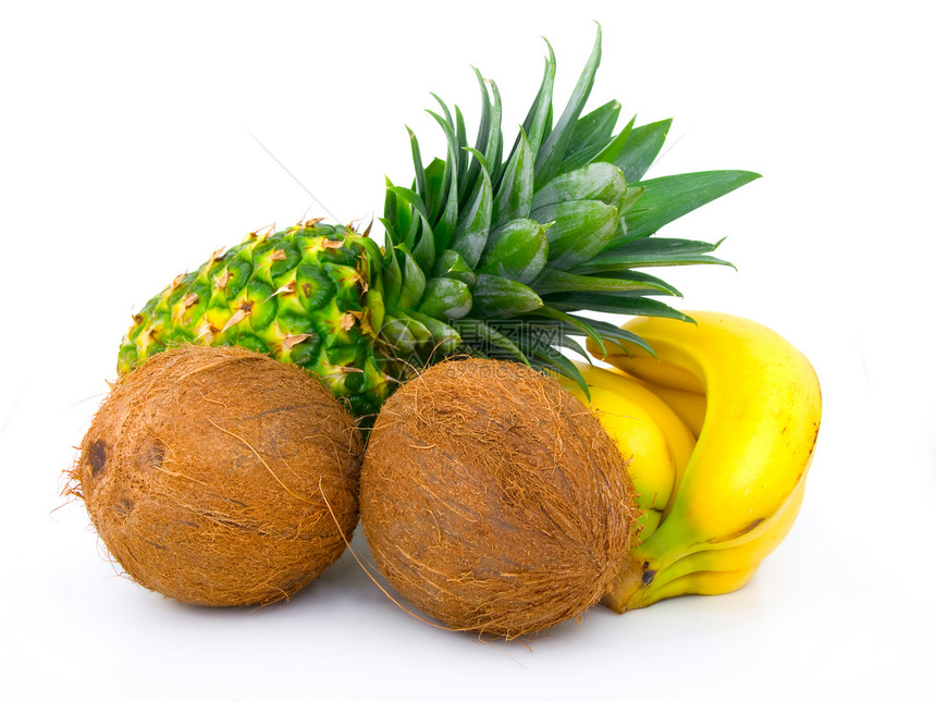成熟的菠萝 一堆香蕉和椰子 在白色的树丛上图片