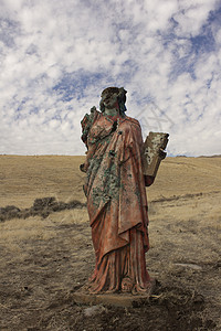 一个无处可逃的死灰复燃的宗教雕像蓝色蓝天上帝黄色红色草地女士女孩礼服背景图片