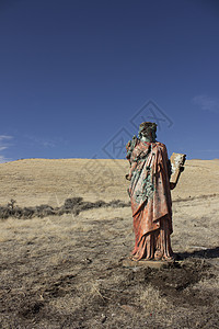 一个无处可逃的死灰复燃的宗教雕像女孩上帝草地黄色礼服蓝天红色女士蓝色背景