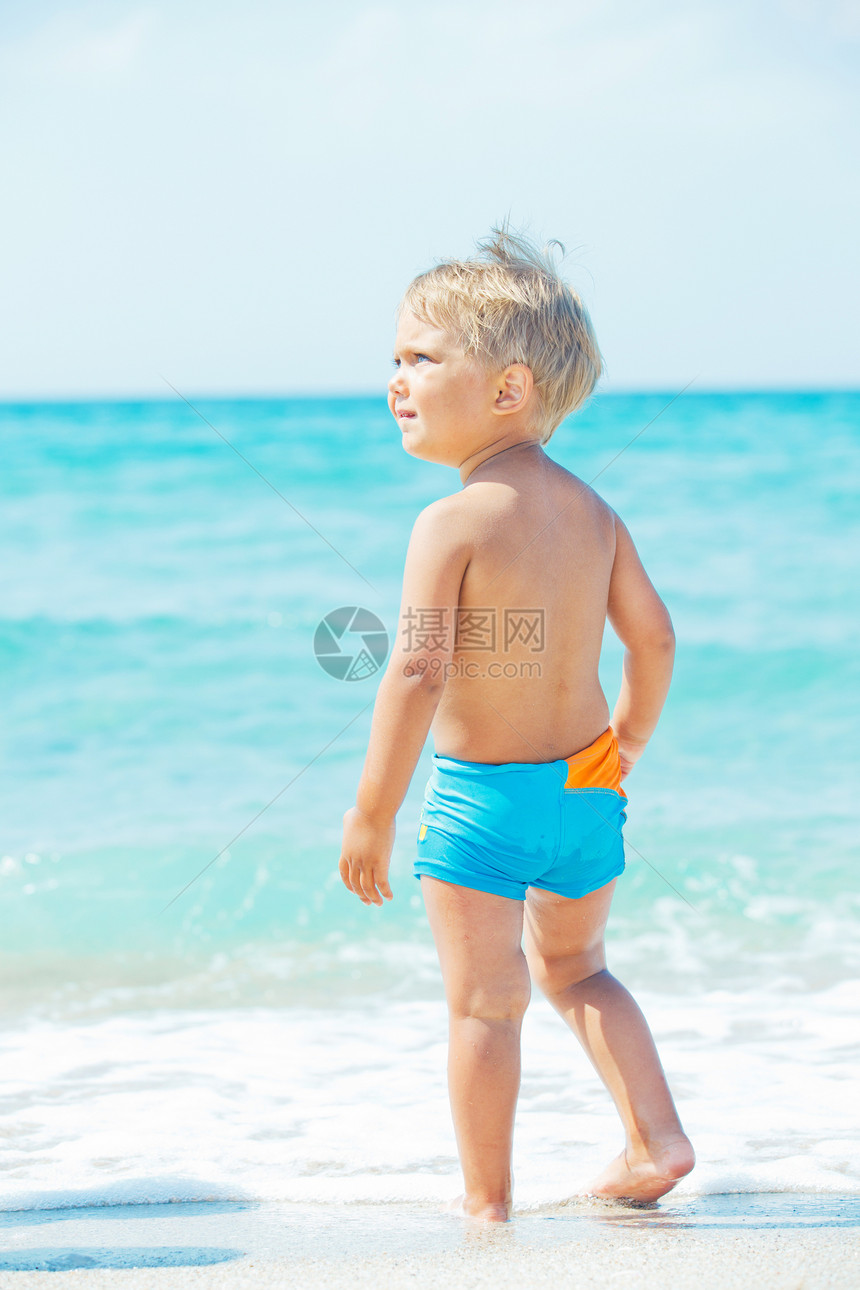 一个可爱的男孩在沙滩上享受乐趣游泳者游泳海洋行动浮潜婴儿冲浪微笑图片
