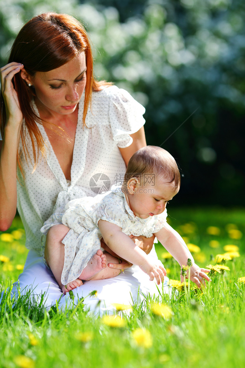 母亲和女儿在绿草上花园童年男生幸福喜悦晴天乐趣成人夫妻花朵图片