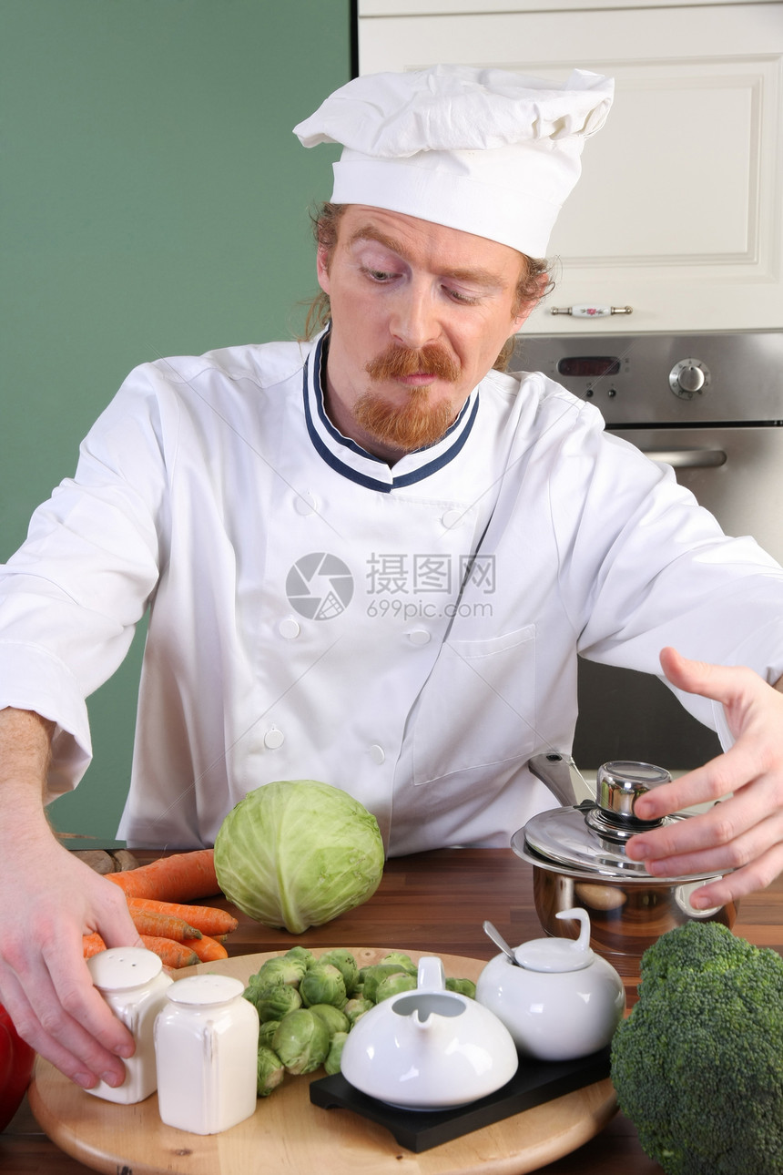 在厨房准备午餐的年轻厨师帽子盘子白色餐具男性美食职业烤箱餐厅烹饪图片