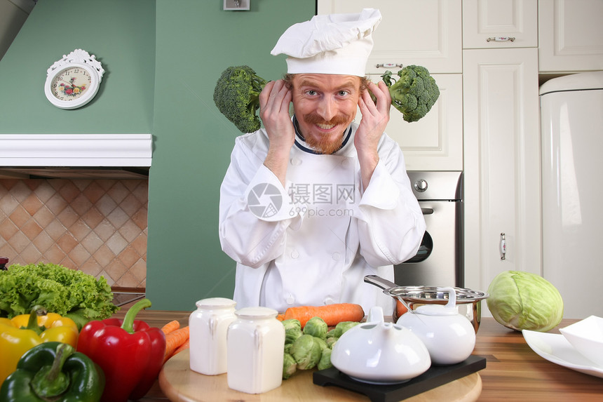 带花椰菜的有趣的年轻厨师烤箱餐具帽子衣服午餐绿色男性职业美食食物图片