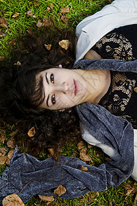 躺倒在地上女性季节公园女士围巾植被树叶青年幸福绿色背景