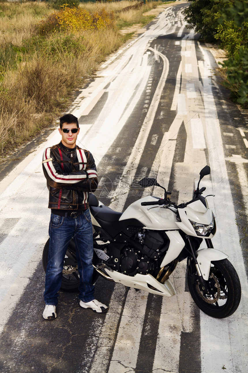骑摩托车的男人旅行发动机冒险运输自行车姿势车辆青年夹克机器图片