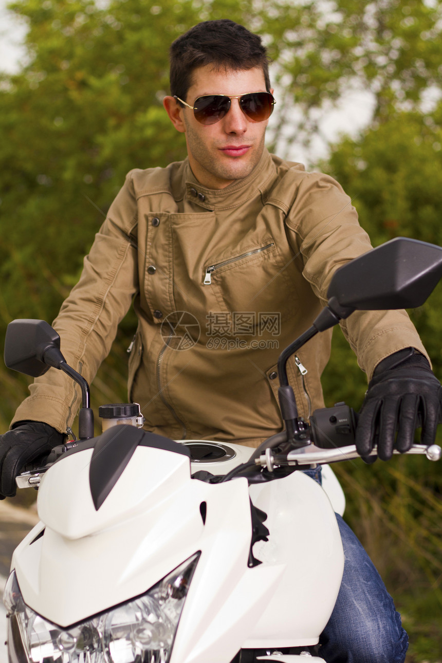 骑摩托车的男人太阳镜发动机司机齿轮沥青青年植被机器运输小路图片