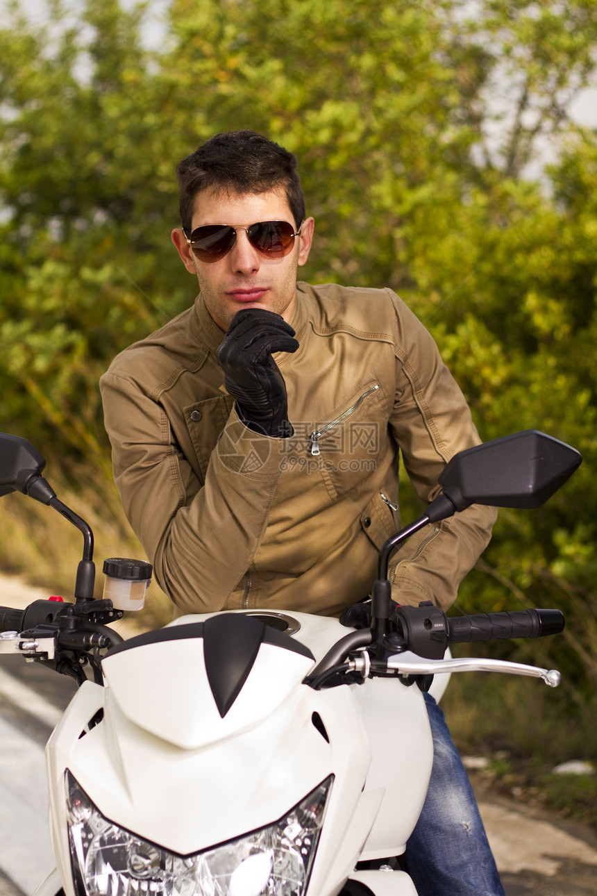 骑摩托车的男人齿轮姿势自行车太阳镜沥青冒险青年男性发动机车辆图片