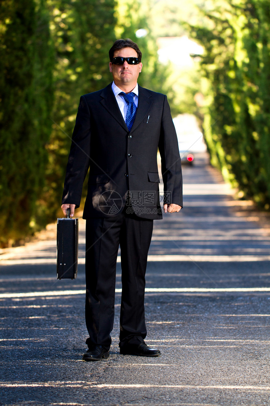 在路上拿着手提箱的商务人士手提箱公园男人夹克工作领带乐趣套装小路街道图片