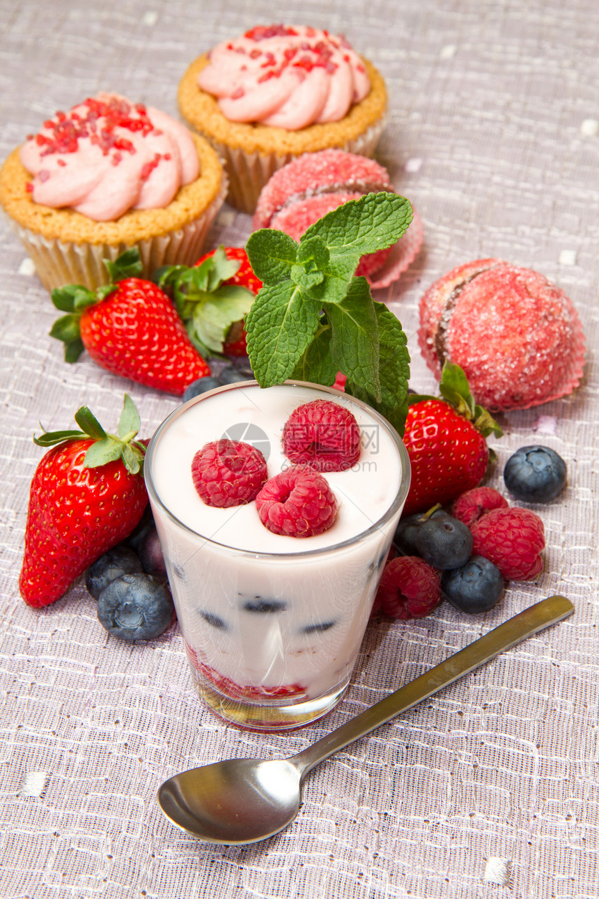 酸奶加浆果和纸杯蛋糕奶油牛奶桌子白色绿色美味粉色营养早餐叶子图片