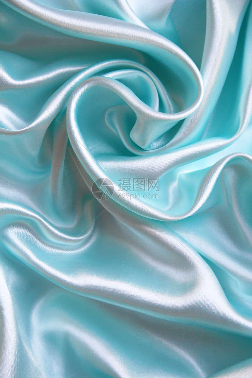 平滑优雅的蓝色丝绸作为背景感性生产织物银色布料材料版税纺织品曲线折痕图片