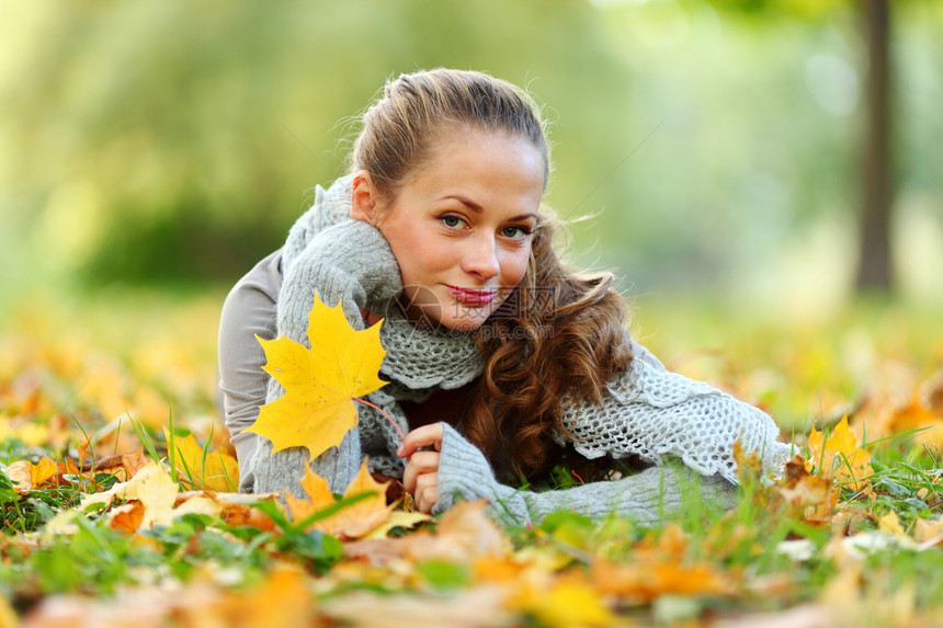 秋叶中的妇女脚尖毛衣叶子女性眼睛公园幸福金发女郎团体乐趣季节图片