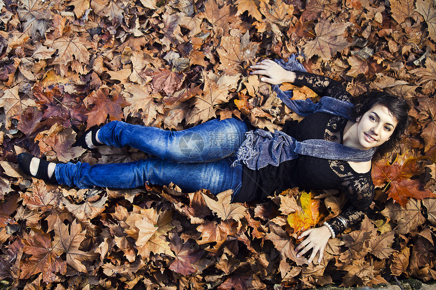 秋季中叶地面黄色森林棕色围巾女性幸福青年公园树叶图片