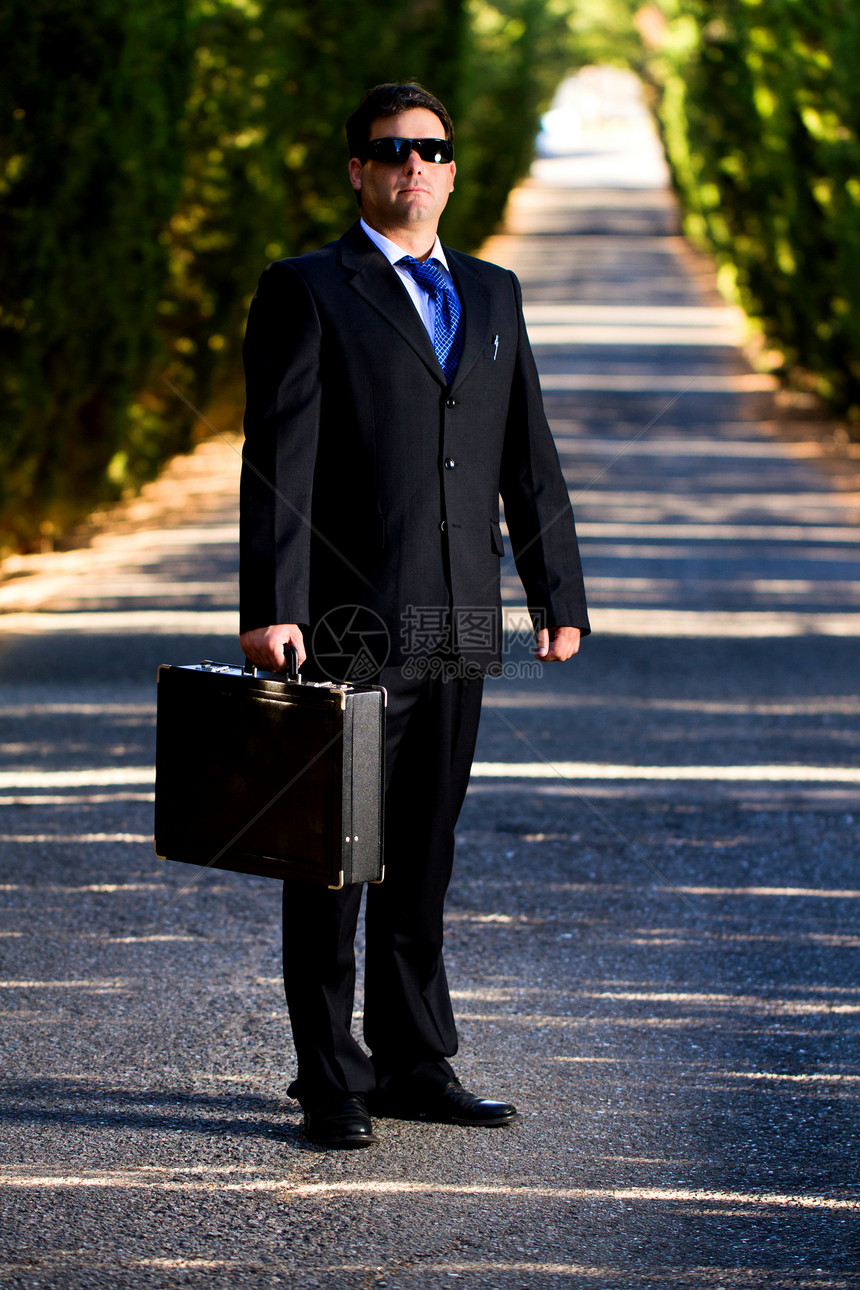 在路上拿着手提箱的商务人士夹克领带街道乐趣男人孤独小路套装手提箱工作图片