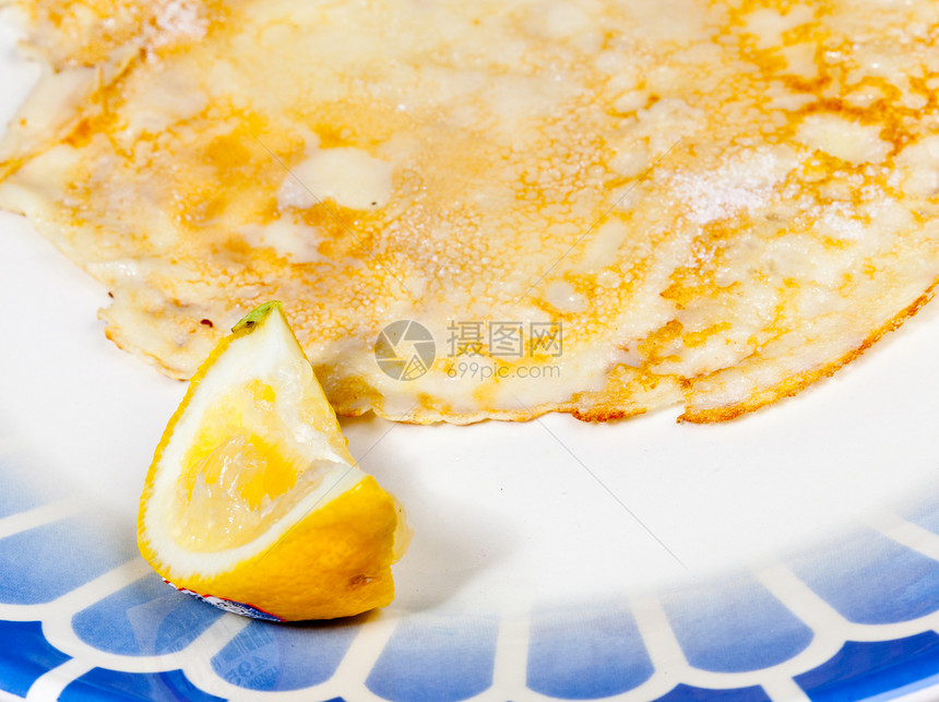 用柠檬煎饼在蓝色盘子上小吃油炸果汁服务午餐柠檬早餐甜点煎饼营养图片