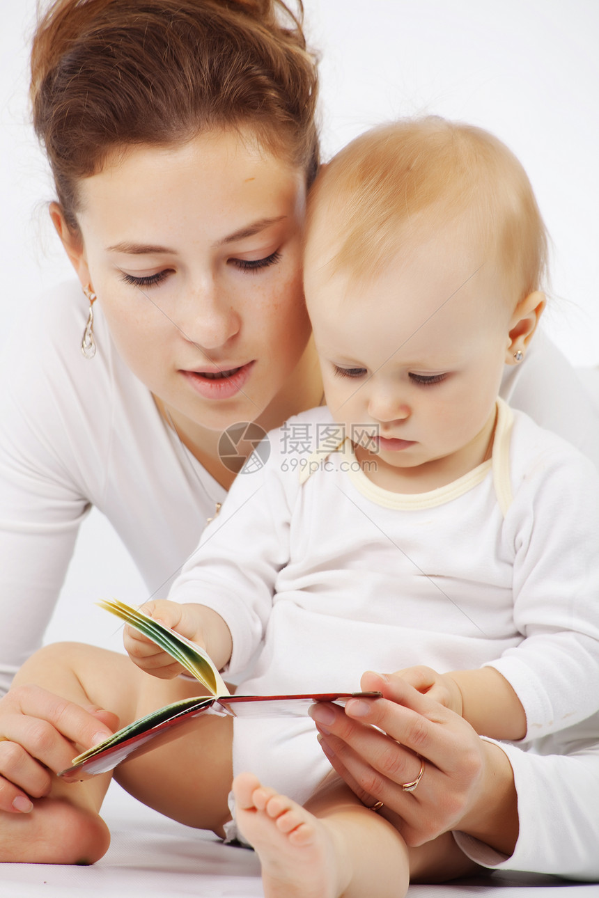 母亲怀着婴儿工作室快乐金发女性女儿阅读衣服育儿女孩妈妈图片