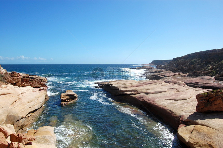 海岸的岩石波浪石头海浪支撑红色悬崖海洋蓝色蓝天图片